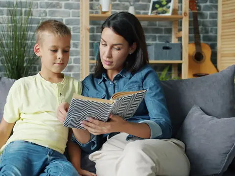 A mother and son reading together on a sofa